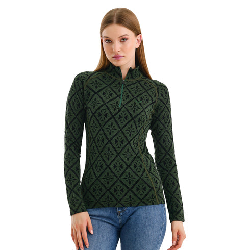 Das Model trägt ein grünes Oberteil aus Merinowolle mit Muster.