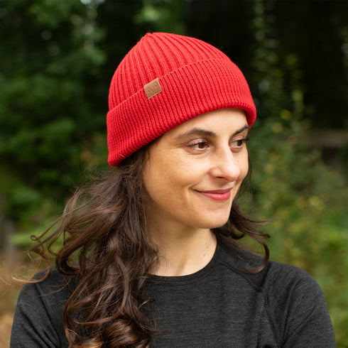 Dame in Merinobekleidung trägt Rote Strickmütze