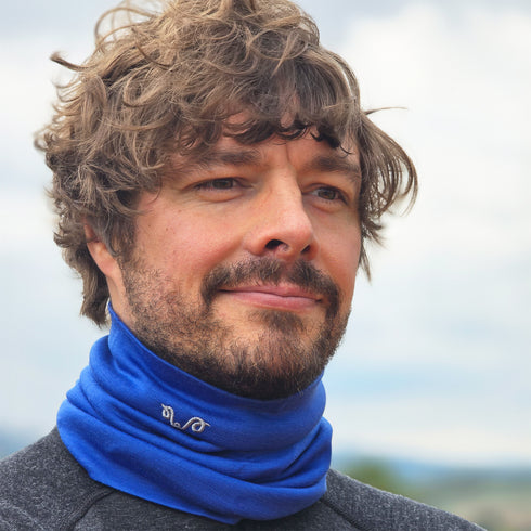 Mann in einem Nackenwärmer in Dunkelblau mit grauem Woolona Logo