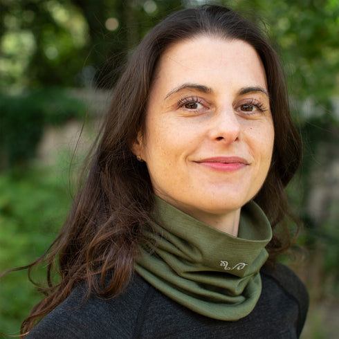 Dame trägt olivgrünen Nackenwärmer aus 100% Merinowolle in der Natur