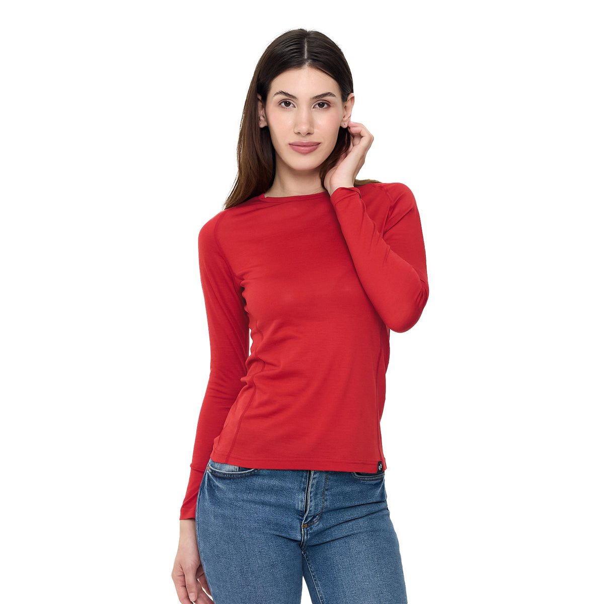 Das Modell trägt ein rotes Langarmshirt aus Merinowolle.