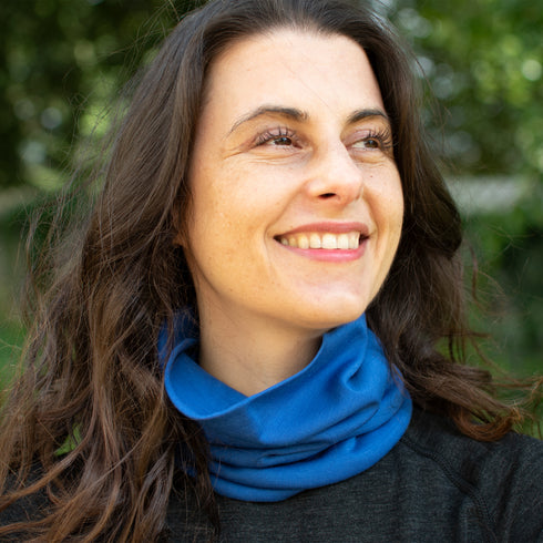 Dame trägt blauen Nackenwärmer aus mulesingfreier Merinowolle im Wald