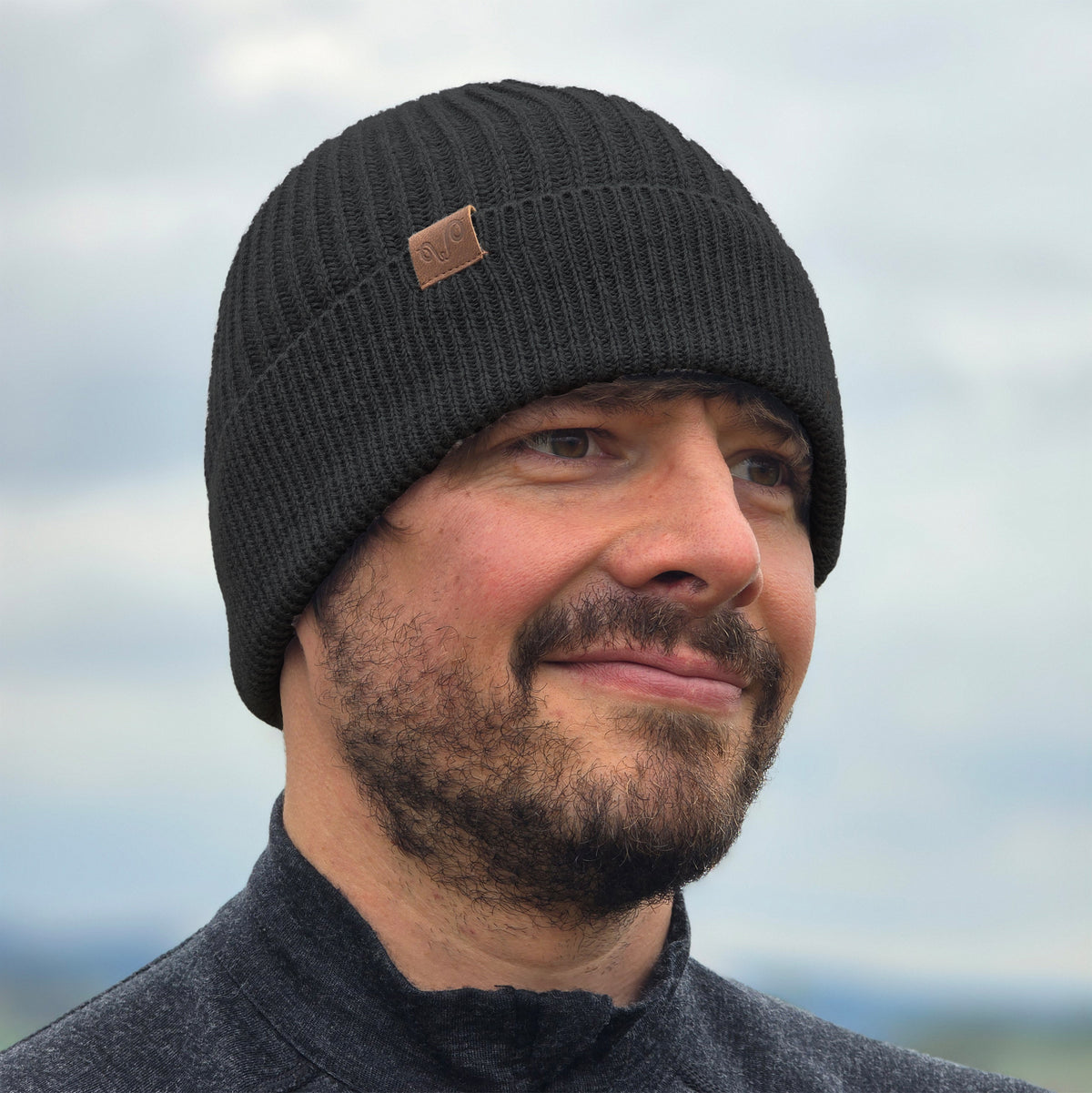 Mann trägt gestrickte Wintermütze aus 100% Merinowolle in Anthrazit.