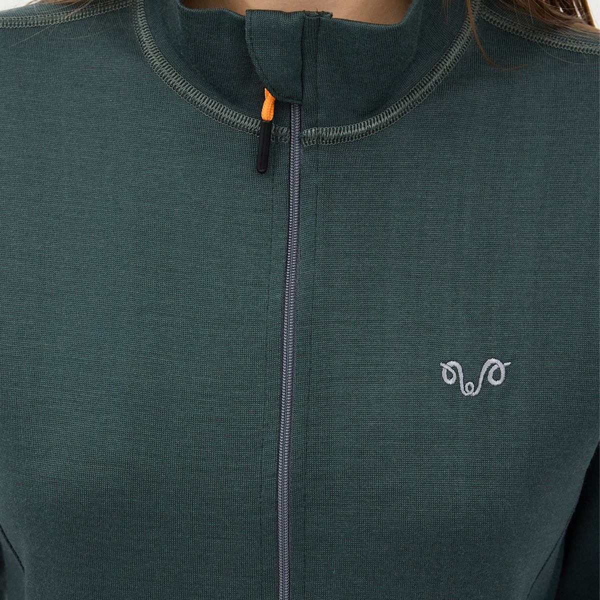 Eine Dame mit einer grünen Jacke aus Merino und einem grauen Woolona Logo.