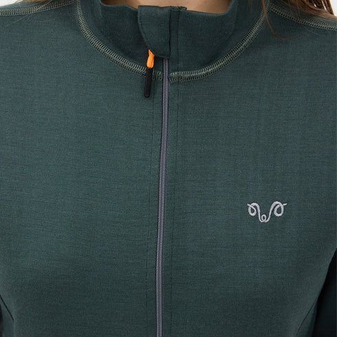 Eine Dame mit einer grünen Jacke aus Merino und einem grauen Woolona Logo.