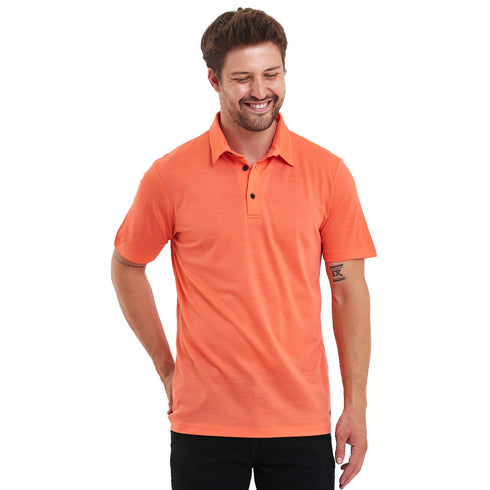 Ein Herr lächelt und trägt ein Lachsfarbenes Merino Polo-Shirt.