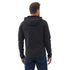 Ein Mann mit dem Rücken stehend, trägt eine schwarze Outdoorjacke mit Kapuze und Jeans.