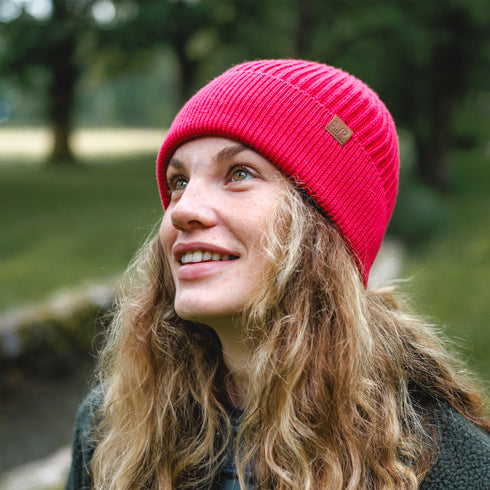 Wanderin mit Fuchsia-Wintermütze in der Natur