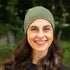 Lächelnde Dame trägt olivgrünen Merinowolle Beanie
