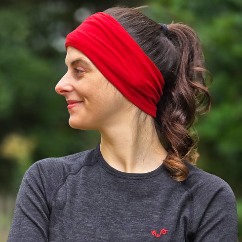 Sportlerin trägt rotes Multifunktionstuch aus 100% Merinowolle als Stirnband