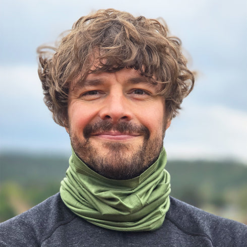 Mann mit Nackenwärmer aus mulesingfreier Merinowolle in der Farbe Olivgrün