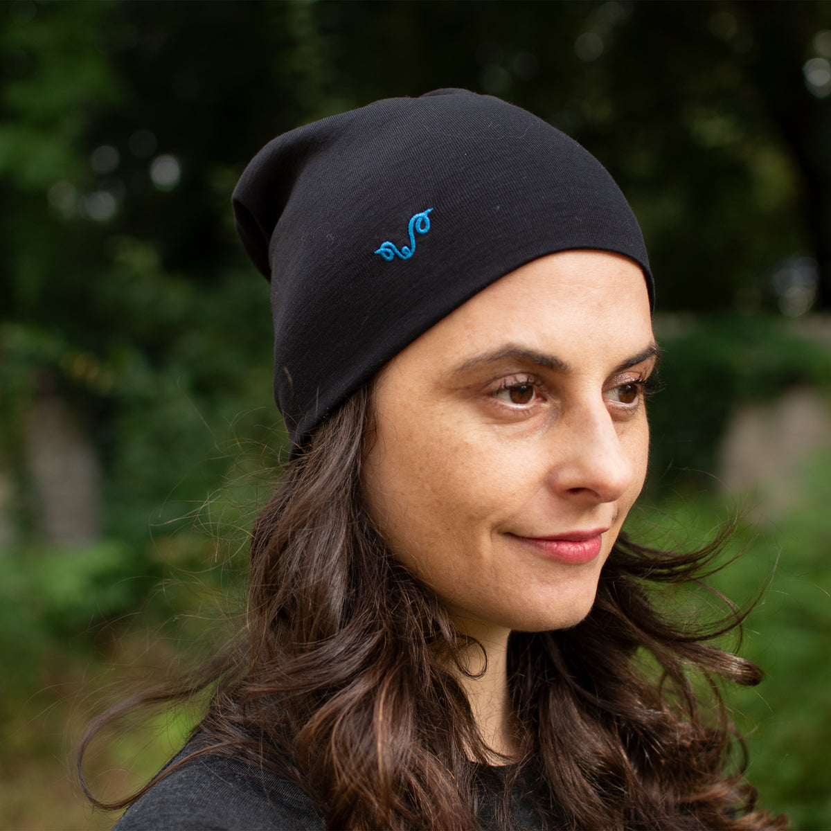 Frau im Wald trÀgt 100% Merinowolle Beanie.