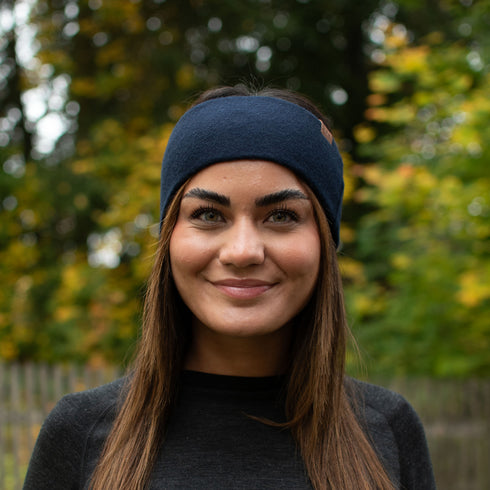 Eine Frau trägt einen 100% Merinowolle Stirnband in der Farbe navy.