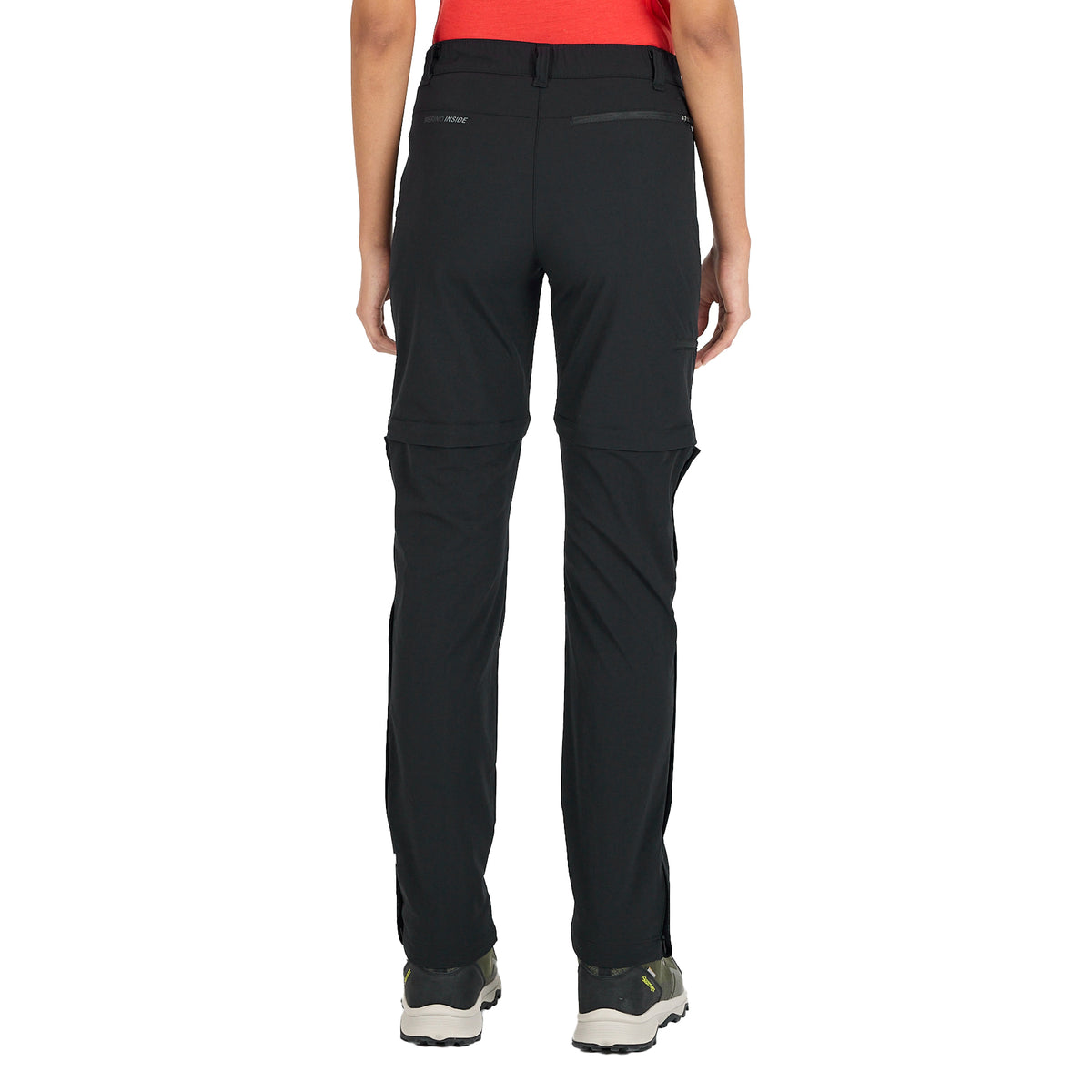 Frau von hinten in einer Merino Zip Off Trekkinghose in der Farbe schwarz.