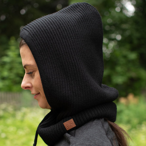 Die Frau trägt einen Kapuzenschal in schwarz.