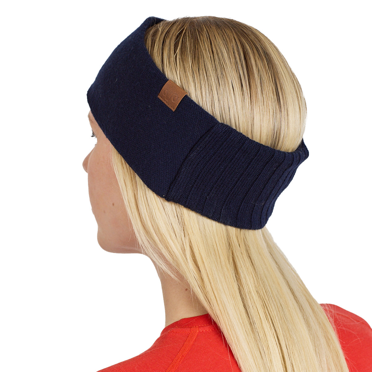 Frau mit einem Merino Stirnband in der Farbe navy mit einem braunen Logo.
