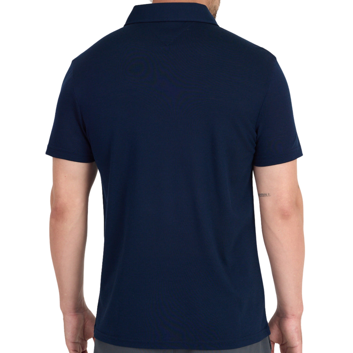 Rücken eines Mannes der ein navy Polshirt aus Merinowolle trägt.
