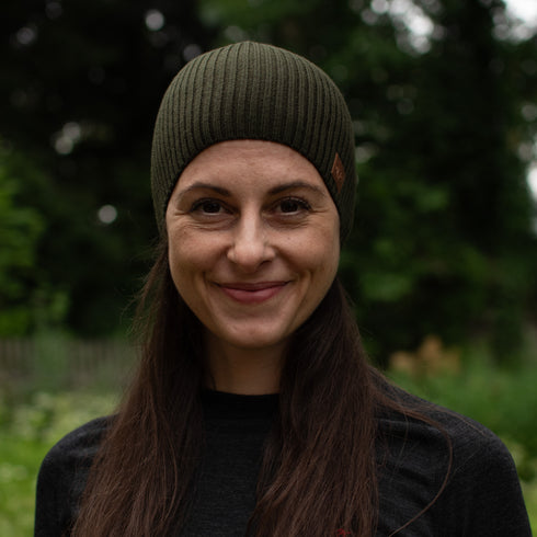 Dame mit einer Mütze aus 100% Merinowolle in der Farbe grün.