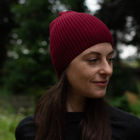 Frau mit einer Merinomütze in der Farbe Bordeaux.