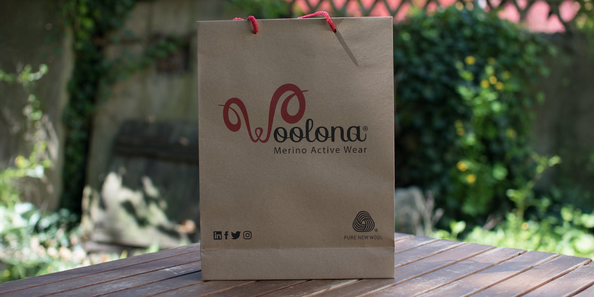 Woolona Geschenktüte draußen auf einem Gartentisch.
