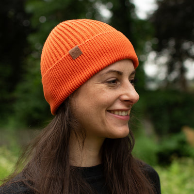 Eine Dame mit Orangenen Winterbeanie aus 100% Merinowolle
