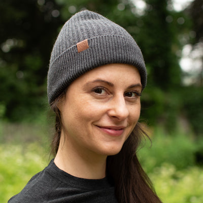 Joggerin trägt Anthrazit-farbene Wintermütze aus Merino.