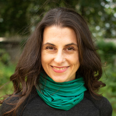 Eine Dame trägt Smaragdgrünes Halstuch aus 100% Merinowolle
