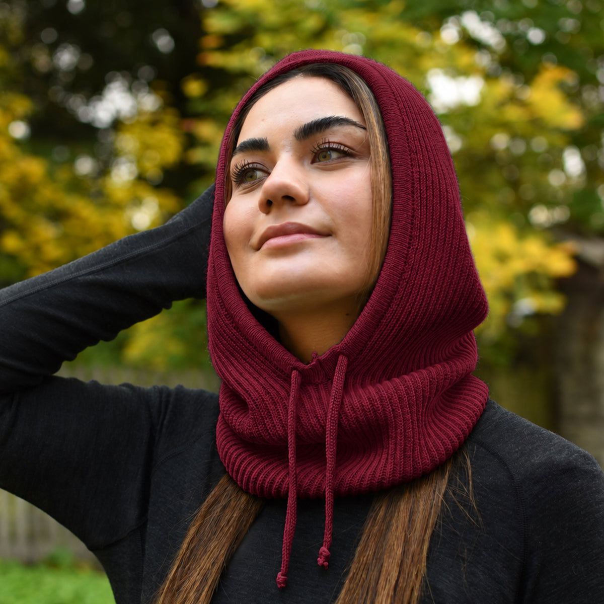 Dame trägt einen Merino Kapuzenschal in der Farbe Burgundy Rot