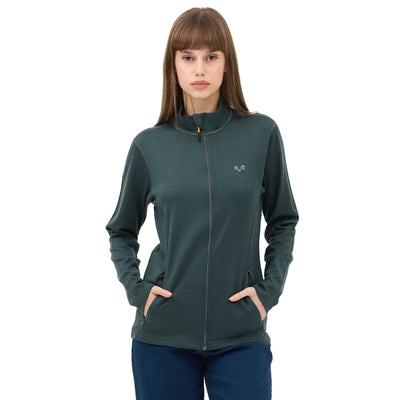 Frau mit einer Merino Jacke in der Farbe grün mit zwei Seitentaschen.