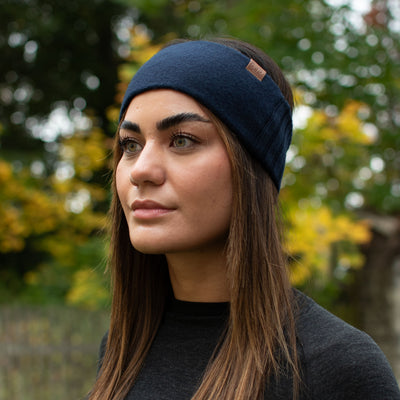 Eine Dame mit einem Merino Strinband in der Farbe navy. 