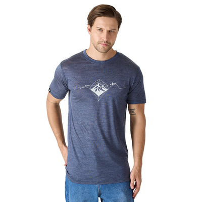 Der Herr trägt ein aus Lyocell und Merinowolle bestehendes T-Shirt in Navy Blau mit weißen Bergen als Aufdruck.