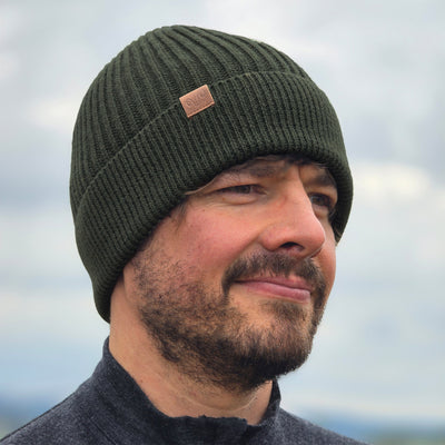 Wanderer trägt Grüne Strickmütze aus Merinowolle
