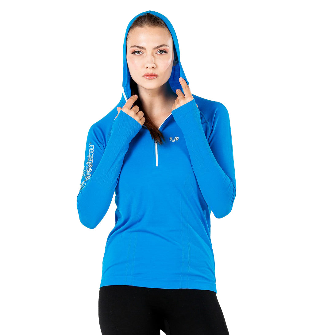 Frau in einem Merino-Hoodie mit Daumenschlaufen in der Farbe Türkis