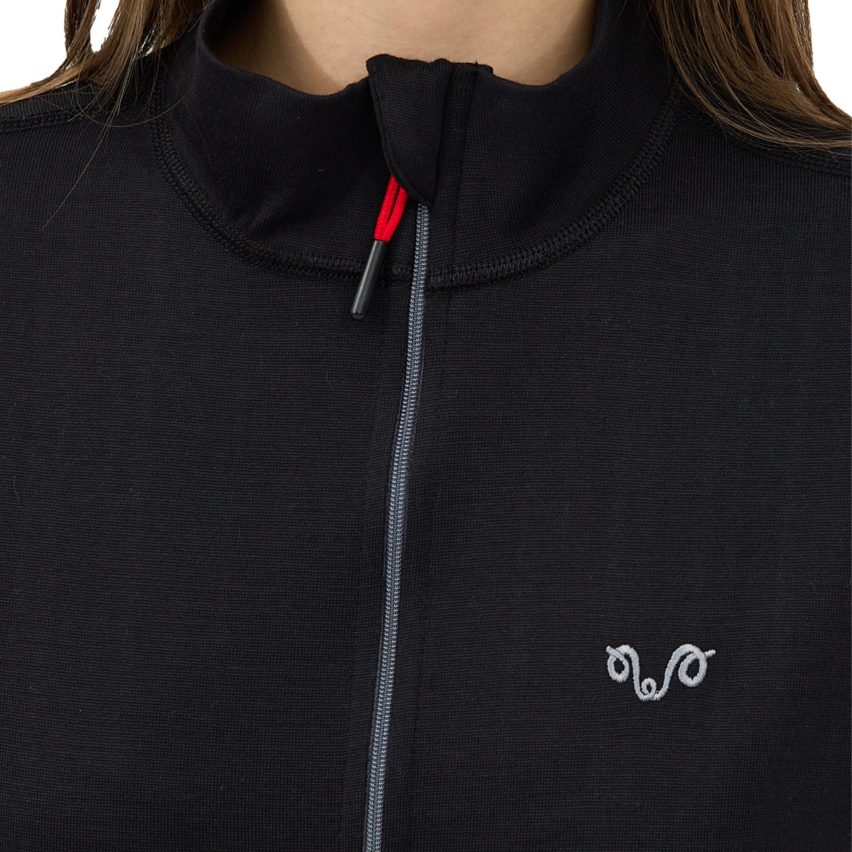 Frau trägt eine schwarze Merino Jacke mit einem Woolona Logo.